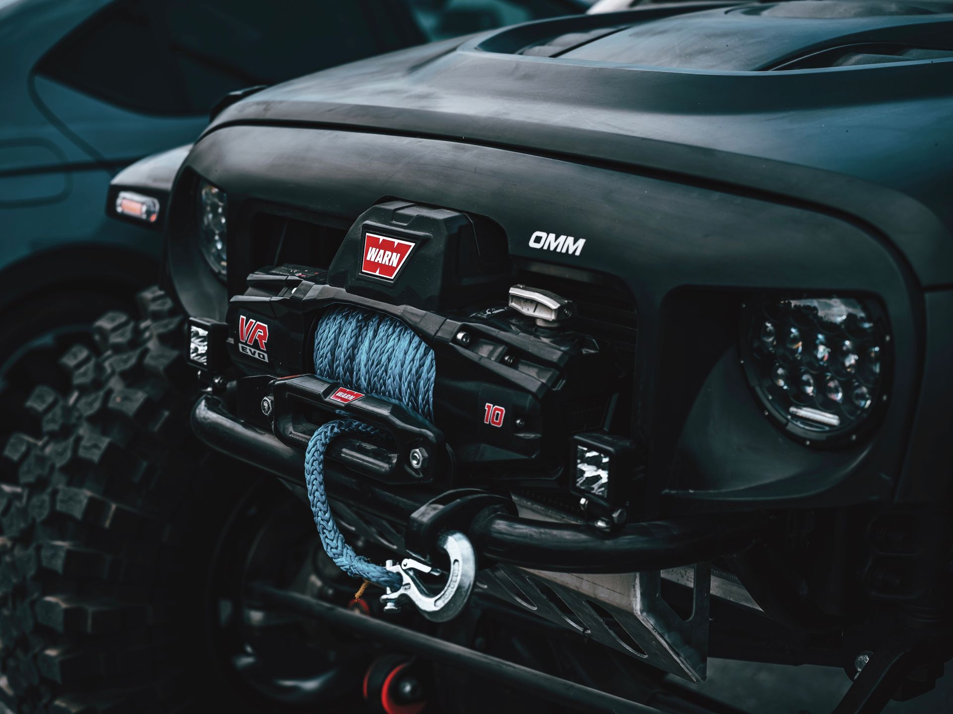 Detailed view of a rugged off-road vehicle featuring a front-mounted winch system, ideal for adventurous terrains.